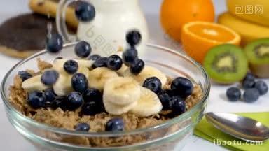 浆果和香蕉水果慢动作落在麦片片上作为早餐健康有机食品